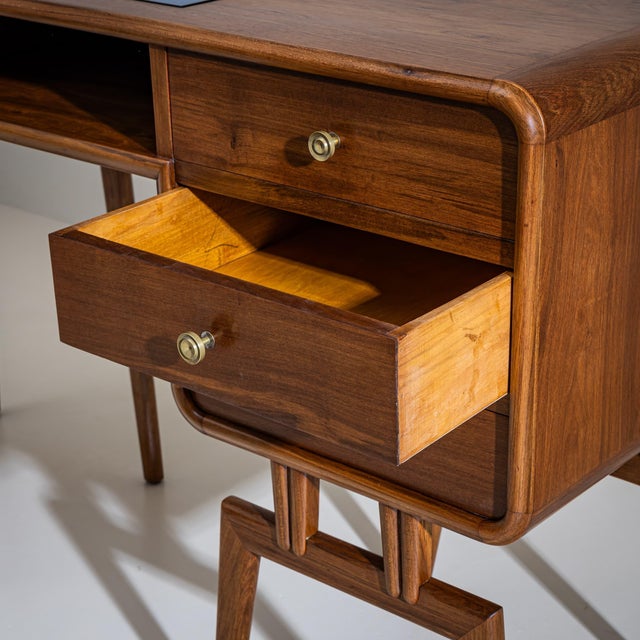 Asymmetrically designed mid-century desk crafted from walnut, featuring four drawers, an open storage compartment, and an...