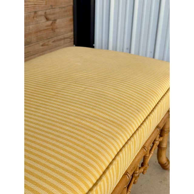 A beautifully crafted bench by Schumacher Furniture, showcasing a faux bamboo style carved wood base with intricate...