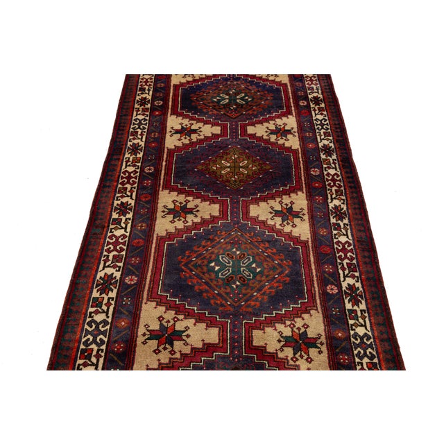 Beautiful hand-knotted Serab Persian wool rug features a tan and navy blue field, accented with brown, red, and green...