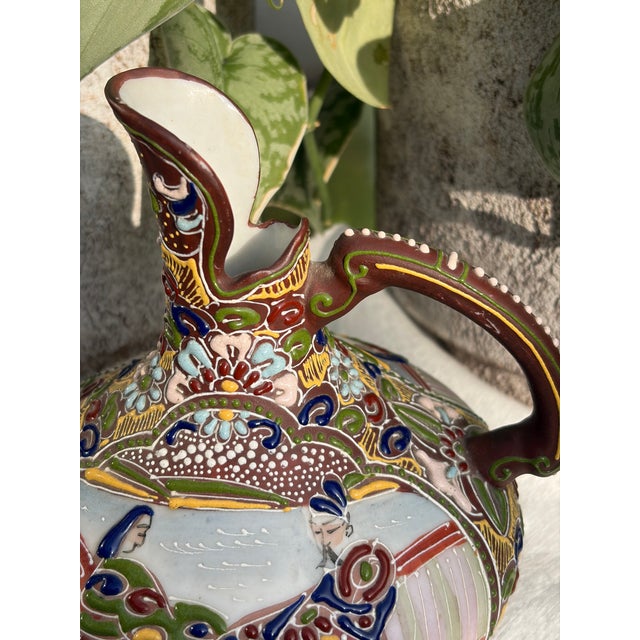 Enameled wine pitcher -the raised layered dots and floral motifs give the ceramic a distinct tactile, three-dimensional...