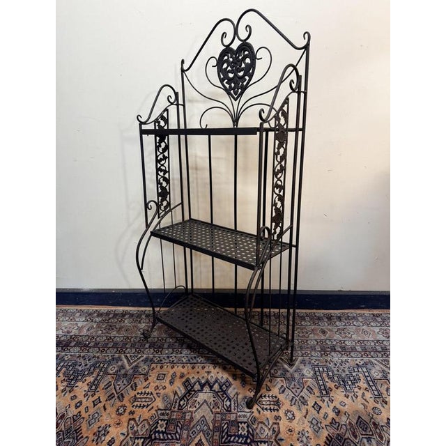 Painted metal outdoor wall shelf with a charming rustic design, ideal as a flower pot stand or decorative garden display....