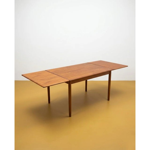 Vintage 1960s Danish teak table with two butterfly extension leaves, an elegant design with rounded corners, perfect for...