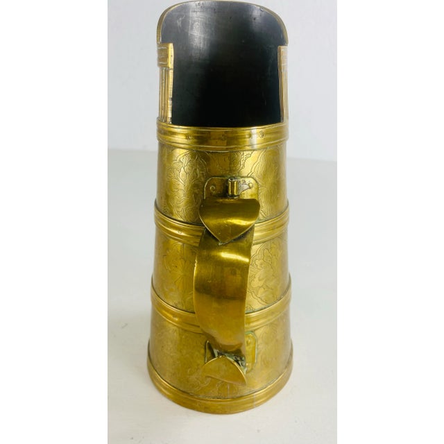 This is a mid 20th century hand forged brass pitcher. This brass vessel has beautifully hand chafed floral decoration...