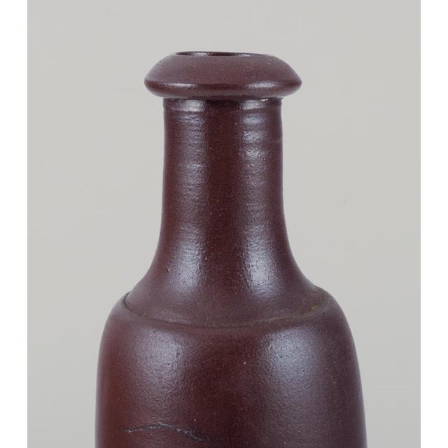French ceramicist. Unique ceramic vase. Slender form. Brown glaze. Mid-20th century. In excellent condition, minor chip at...