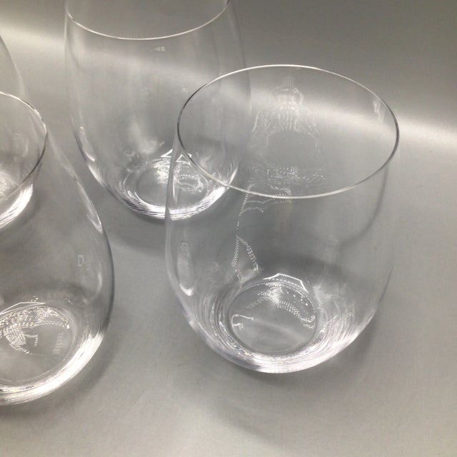 Four thin and light crystal Riedel stemless wine or scotch glasses with Riedel etched on the bottom. (Shown in photo...