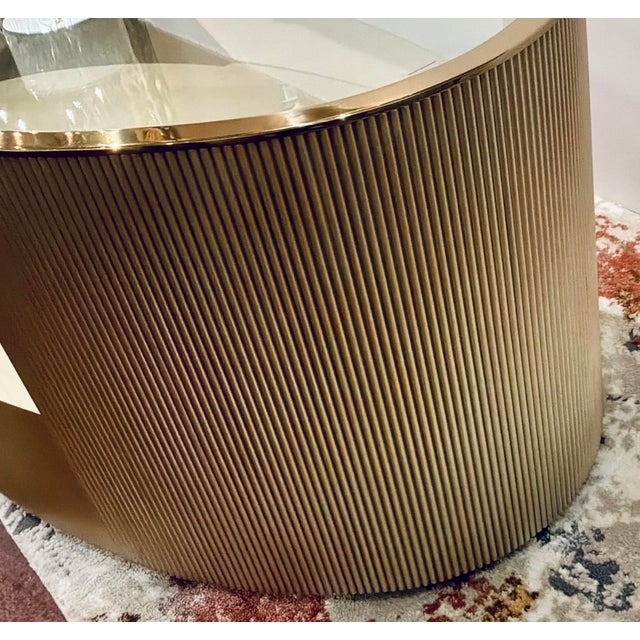 Original retail $5485, stylish Caracole Modern Champagne Finished Love Oval Cocktail Table, fluted sides, thick glass top...