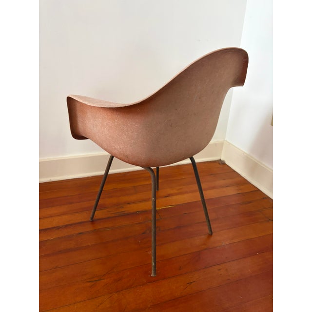 Authentic mid-century Eames fiberglass arm shell chair for Herman Miller, featuring the iconic sculptural form that...