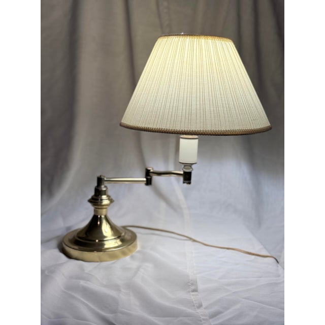 Classic vintage brass swing-arm table lamp with adjustable arm and fabric pleated shade. Traditional library / desk style...