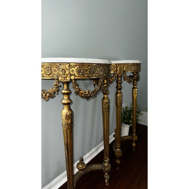 Authentic original pair of Louis XVI demi-lune console tables, crafted in the mid-19th century. These pieces feature hand-...