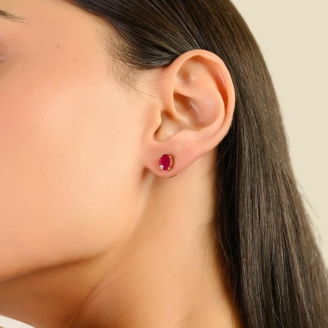 These elegant stud earrings featuring 2 oval cut rubies totaling 1.82 carats, set in 14k yellow gold. Each ruby measures...