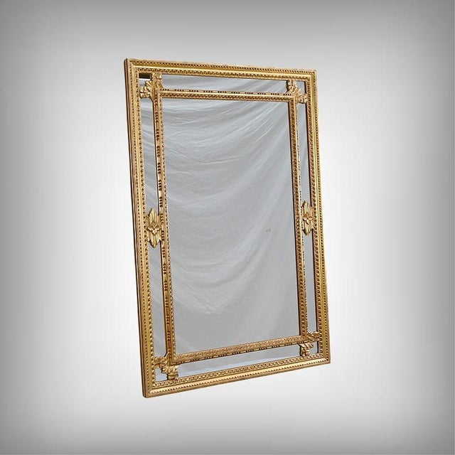 An elegant Louis XVI style mirror with moldings, distinguished by the finesse of its giltwood frame and the presence of...