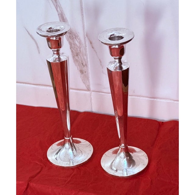 A pair of weighted sterling silver Art Deco candlesticks measures 10 1/8 in. tall, 2 1/8 in. in diameter at the top, and 3...