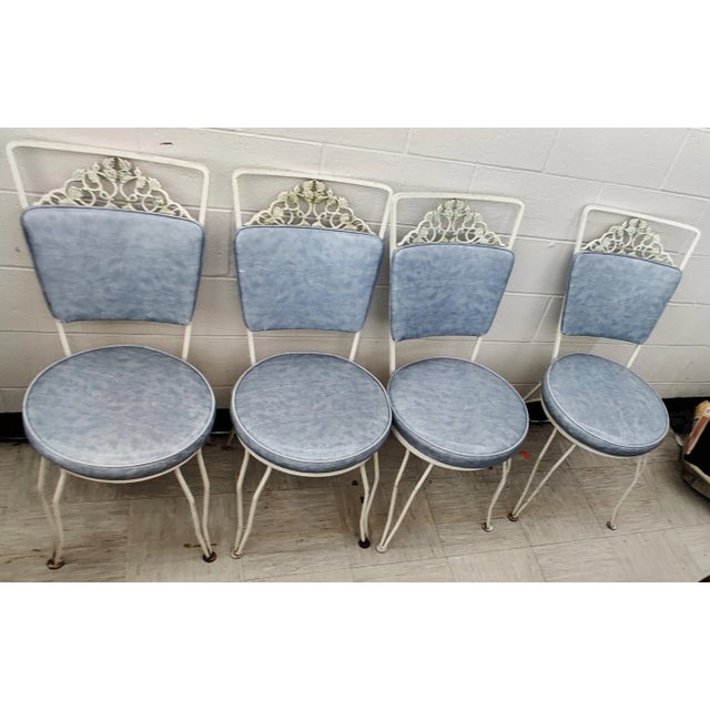 Set of four vintage iron dining chairs, white with blue vinyl seats and backs and floral detail on top.