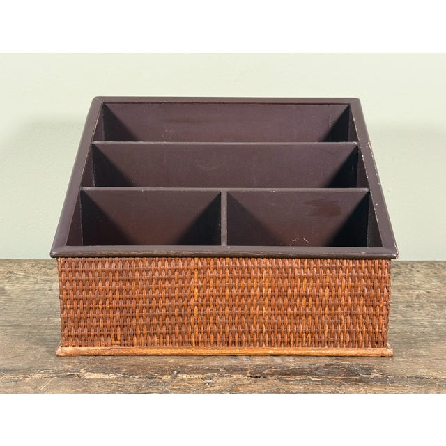 This desk organizer features a woven rattan exterior wrapped around a wood frame with a brown painted interior. The piece...