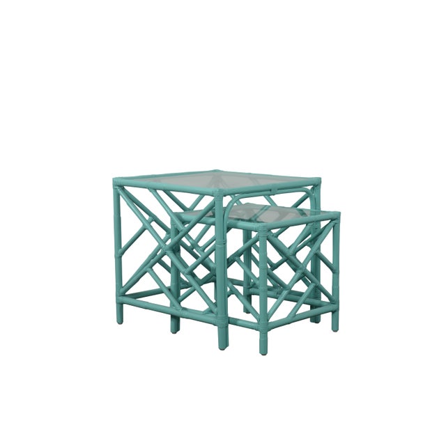 In a classic chinoiserie style, this set of two rattan nesting tables feature a rattan frame, rawhide bindings, hand...