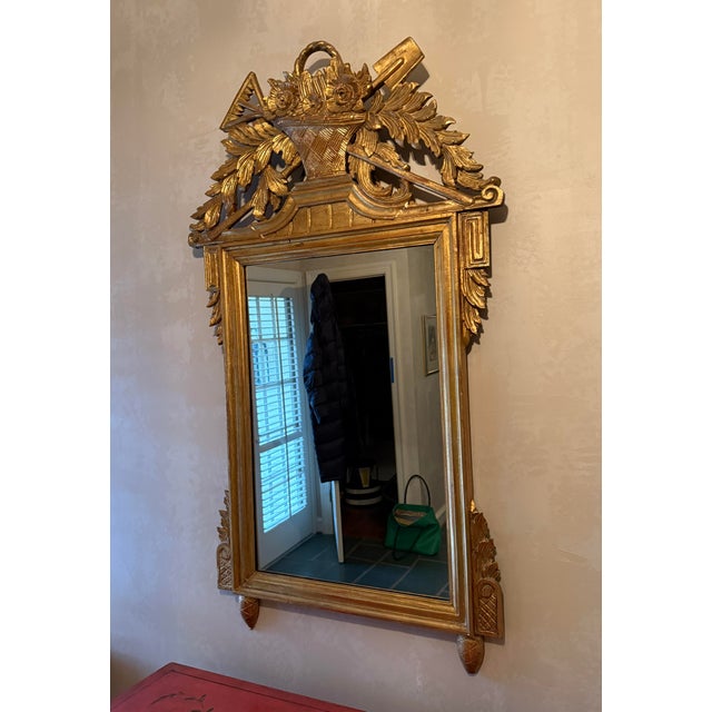 Large Louis XVI Style Giltwood Mirror with ornately carved crest featuring gardening / harvest themes. The carvings...