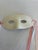 A vintage ceramic masquerade mask featuring a glossy cream finish, oval eye openings, and a softly sculpted nose. Pink and...