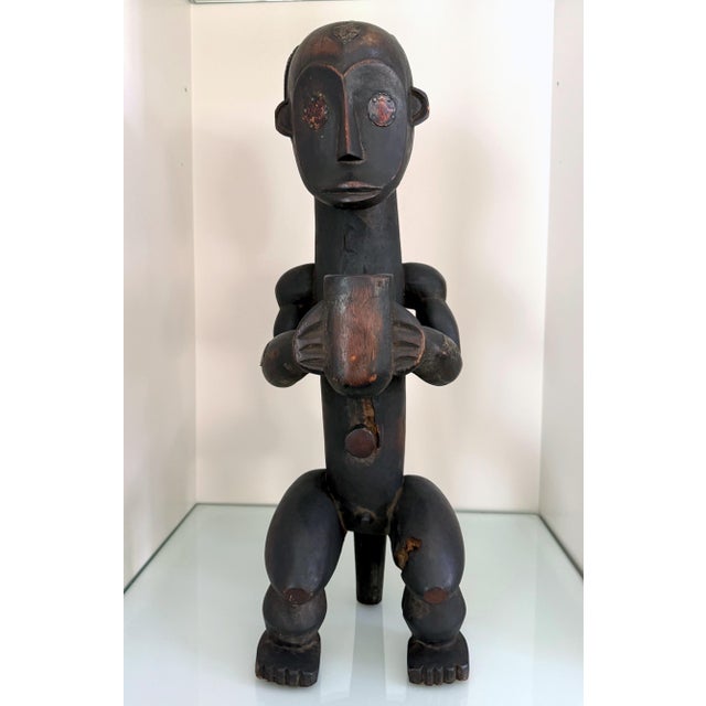 Carved out of a single block of wood, this Gabon Fang male reliquary statue of stylized proportion impresses the viewers...