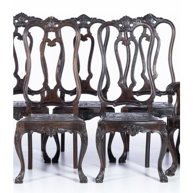 Set of two armchairs and seven chairs Portuguese, late 19th century, made of rosewood. Open backs, leather seats with...