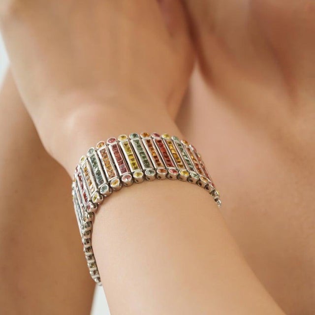 This striking wide statement bracelet showcases 48.70 carats of natural multicolored sapphires in a beautiful mix of...