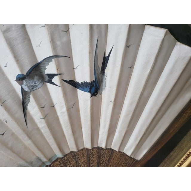 An exceptional statement piece of spectral elegance, this rare antique hand-painted silk fan is meticulously preserved...