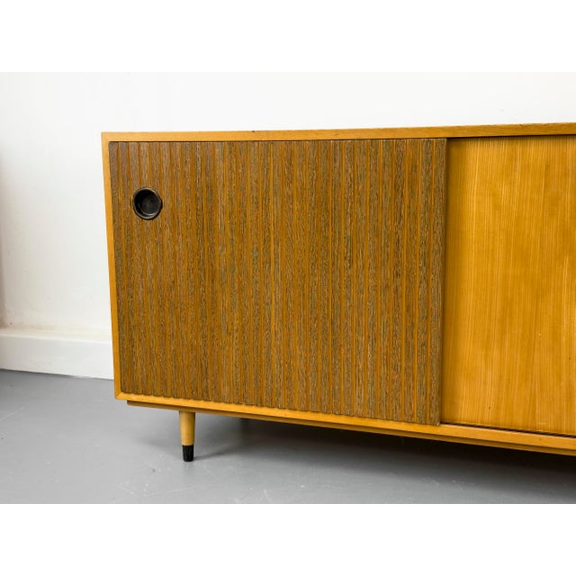 Practical sideboard with two sliding doors and two adjustable shelves inside. High-quality construction with striking...