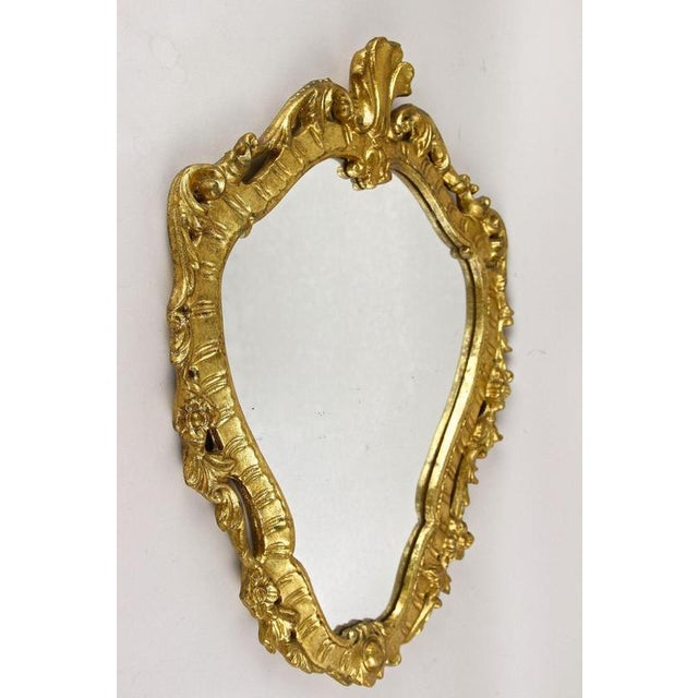 Elegant 18th century gilt wall mirror from the late baroque period around 1790 in Italy. The artfully handcarved, partly...