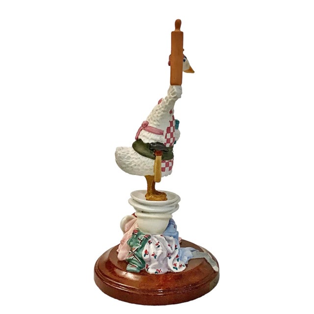 A fun collectible figurine depicting “Super Mom”. She holds a cookbook, wears a tool belt, and stands on a mountain of...