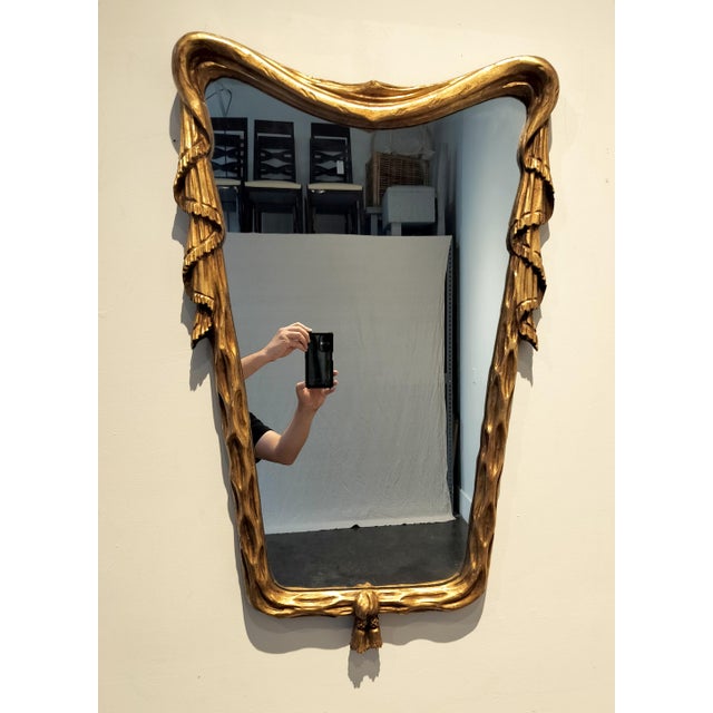 Mid century mirror with unique shape and design. Solid wood with plaster and gold finish. 35" high x 22" wide. Circa 1965.