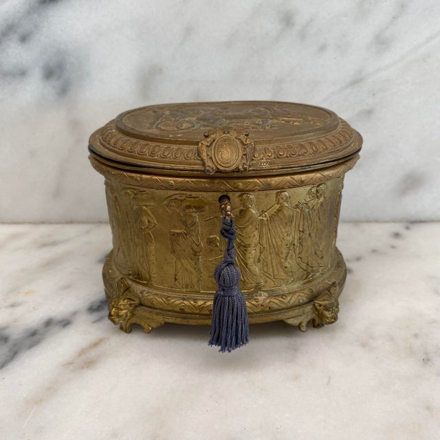 This exquisite A.B. Paris French 19th Century Gold Repousse Neoclassical Jewelry Casket Box with Original Key is a...