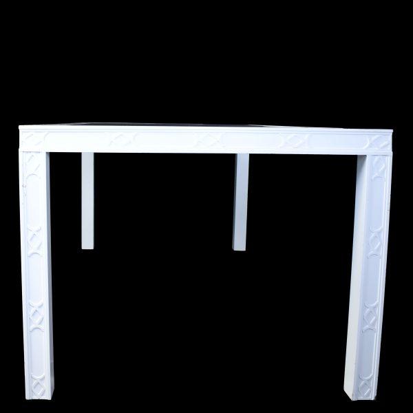 A large Hollywood Regency dining table with ornate fretwork detailing, made for glamorous entertaining. The fretwork apron...