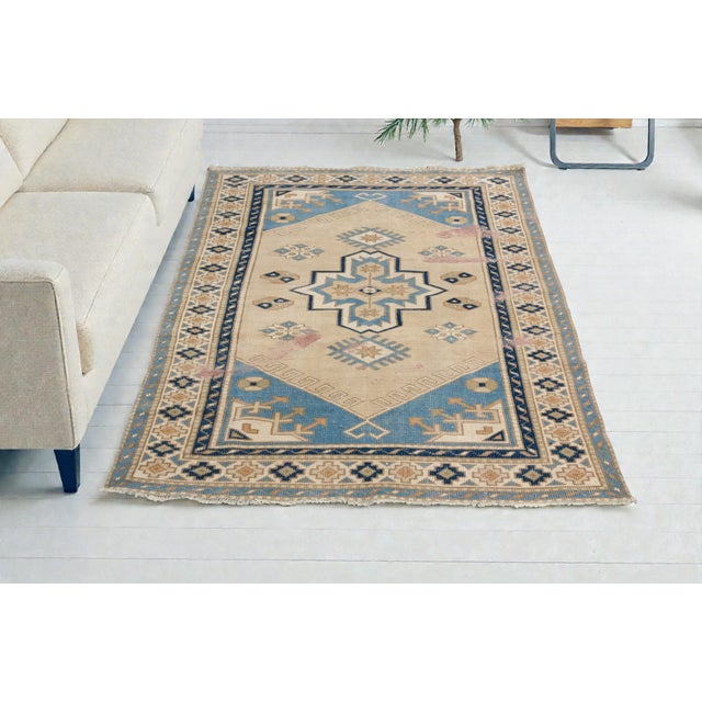 This is a vintage Turkish Oushak rug from the Mid 20th Century. The piece was hand-knotted.