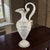 The Neo-Classical Ewer by Ardalt Capoimpero is a stunning piece of Italian bone china, adorned with a delicate figural...