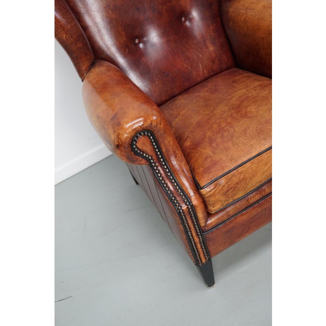 This cognac-colored leather club chair comes from the Netherlands. It is upholstered with cognac-colored leather and...