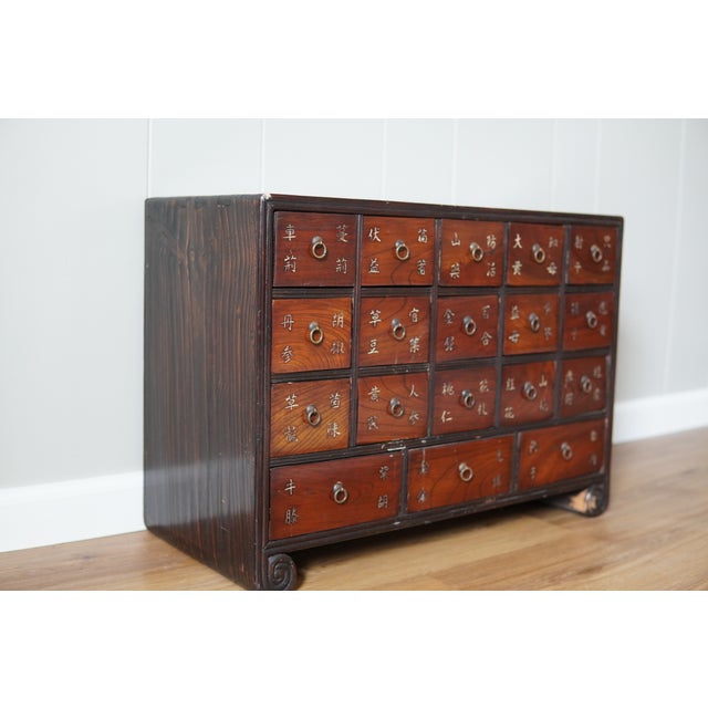 This striking pair of Chinese apothecary cabinets features an array of small drawers traditionally used for storing herbal...
