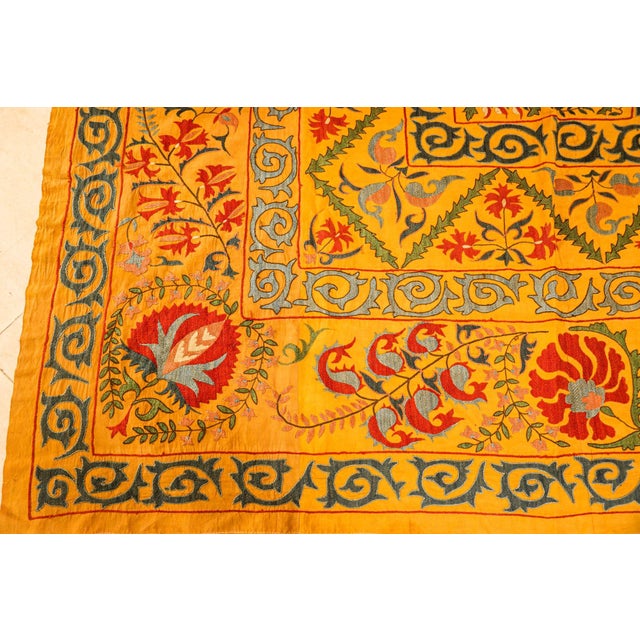 Very large vintage Turkish Suzani is heavily hand-embroidery with faded organic yellow, blue and red colors silk...
