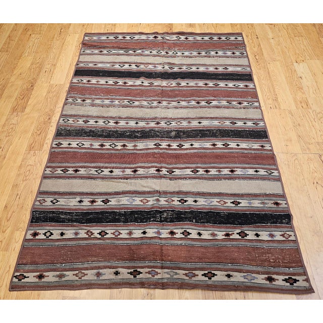 Woven over a century ago by the nomadic Shahsavan tribes of Northwest Persia, this rare early 1900s kilim is a beautifully...