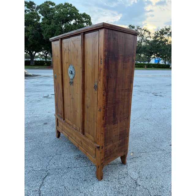Overview A magnificent and authentic 19th-century Chinese four-door armoire, expertly hand-crafted from solid elmwood...