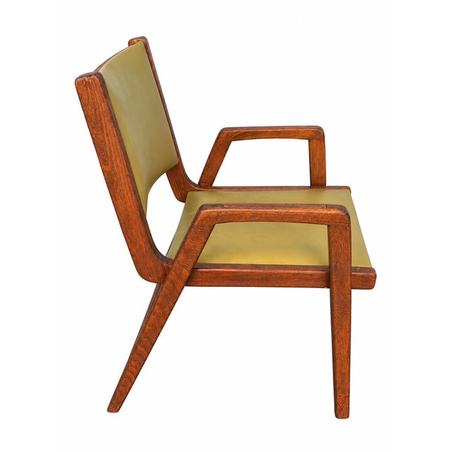 A striking pair of vintage mid-century modern armchairs featuring sculptural angular wood frames and original avocado-...