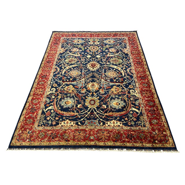 This Bijar Persian style wool rug has a deep navy blue field filled with large flowers, curved vines, and smaller...