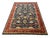 This Bijar Persian style wool rug has a deep navy blue field filled with large flowers, curved vines, and smaller...