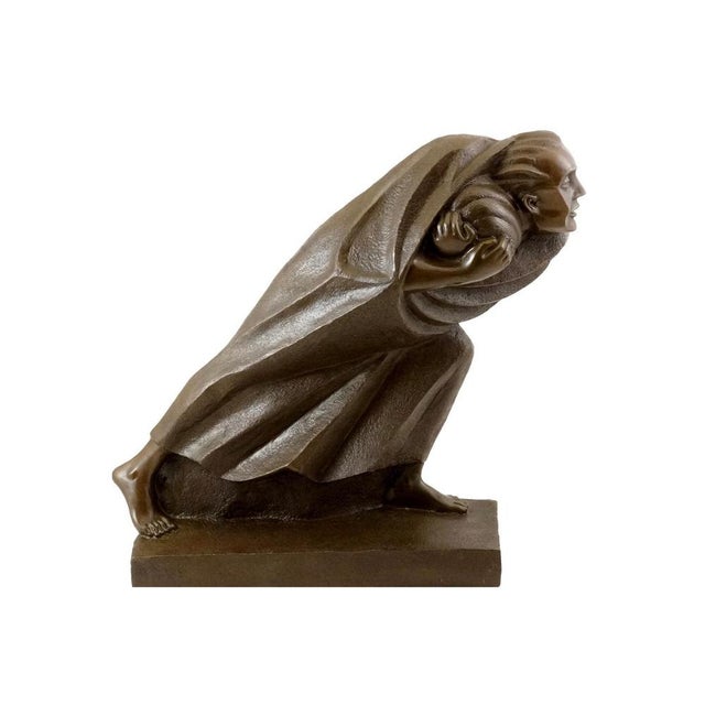 This bronze sculpture illustrates a figure leaning forward in a determined walking stance. The character clutches a sack...