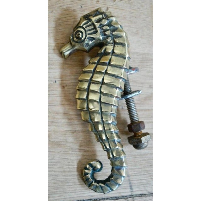 An unusual antique British door knocker fashioned in the form of a seahorse, combining functional architectural hardware...