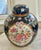 Vintage chinoiserie ginger jar with lid. Beautiful blue backdrop with a pretty floral design of pink, orange, and purple...