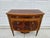 This gorgeous Louis XVI style mahogany chest of drawers features plenty of ormolu or brass-colored appliques. The handmade...