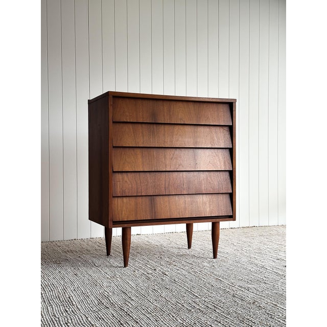 This vintage mid century five-drawer chest features a striking architectural facade defined by deeply recessed drawer...