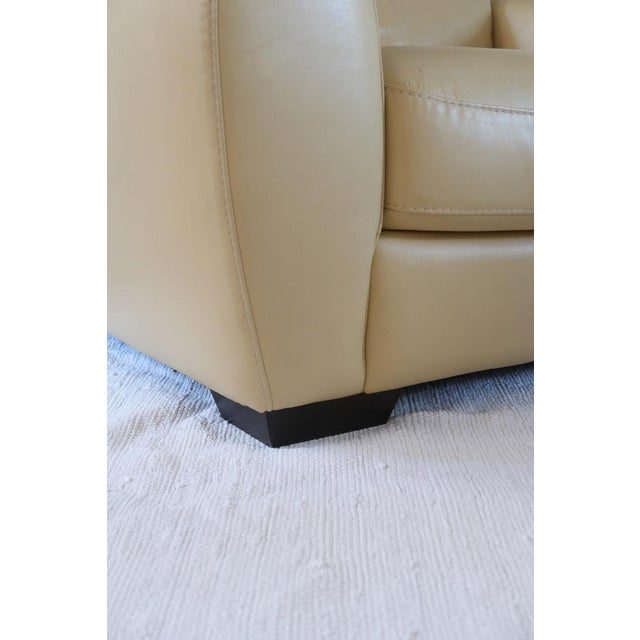 A generous postmodern club armchair from the 1980s, upholstered in butter yellow faux leather. The low rounded silhouette,...