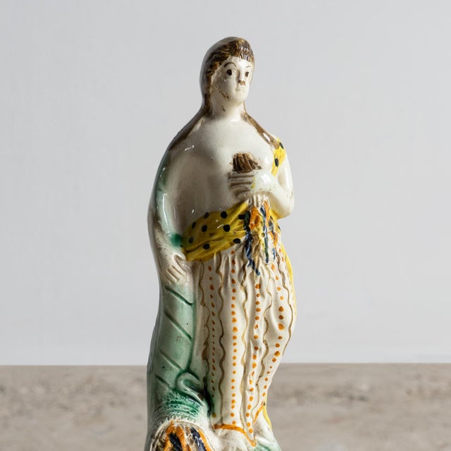 ANTIQUE ENGLISH CERAMIC FIGURINE A wonderfully charming figure depicting the Roman goddess of flowers and spring, Flora....
