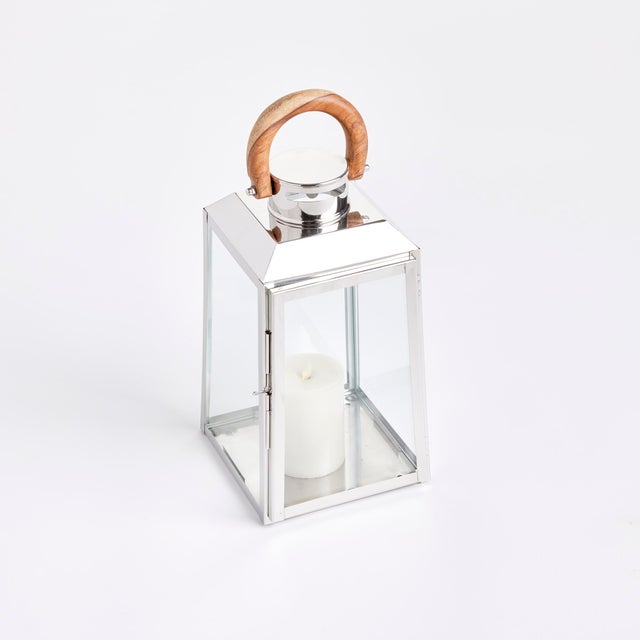 Nautical in style, this handsome outdoor lantern shines brilliantly in a chrome finish and real teak wood handle. Add a...