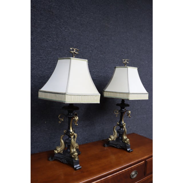 Exceptional pair of French Empire-style bronze table lamps featuring elaborate figural bases with three sculpted dolphins...